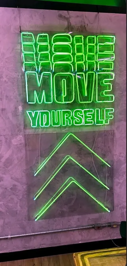 Letreiro em neon verde instalado em ambiente comercial