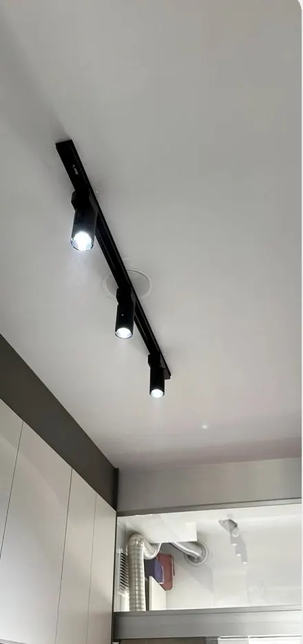 Trilho preto com spots direcionáveis no teto da cozinha
