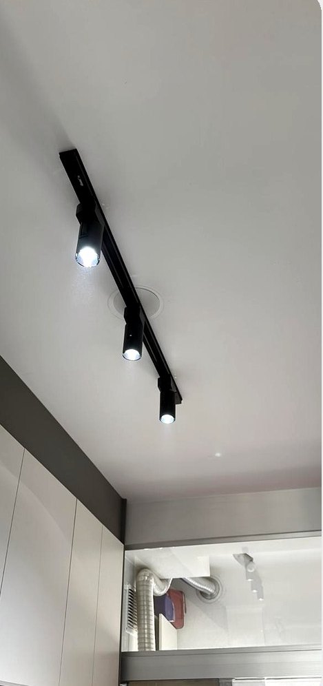 Trilho preto com spots direcionáveis instalado no teto de cozinha residencial pela MTECH Elétrica